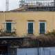 ...e si presenta con un colore giallo ocra e arcate e finestre rettangolari. Ha l’aspetto di una residenza o un luogo con funzione direzionale